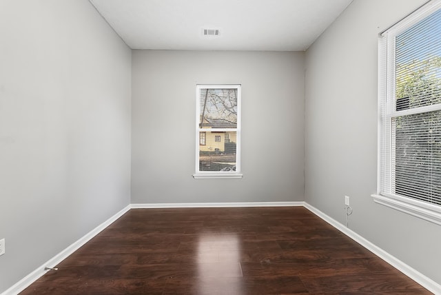 unfurnished room with dark wood-type flooring