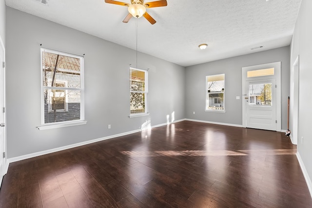 interior space with ceiling fan, dark hardwood / wood-style flooring, and a textured ceiling