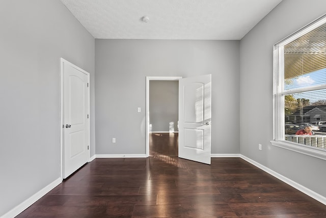 unfurnished bedroom featuring dark hardwood / wood-style floors and a textured ceiling