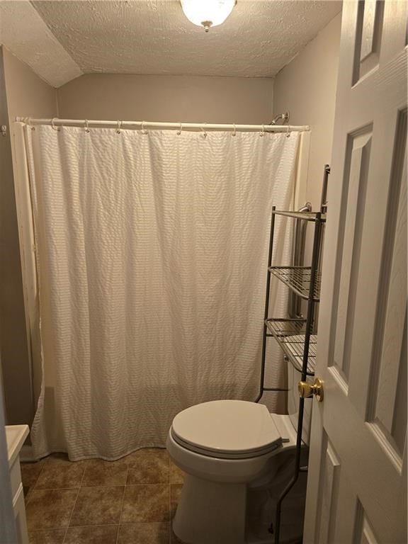 1009 11th St, Phenix City, AL 36867 - full bath featuring a textured ceiling, vaulted ceiling, a shower with curtain, tile patterned flooring, and vanity
