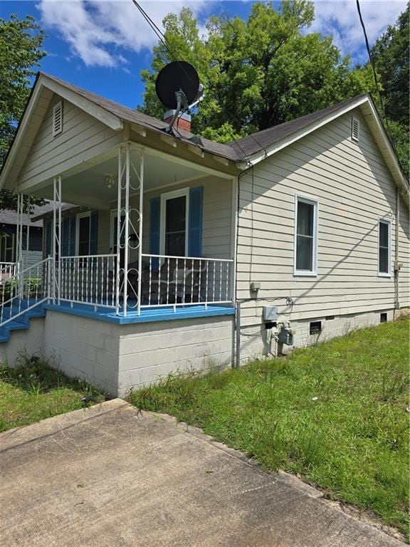 1009 11th St, Phenix City, AL 36867 - view of property exterior featuring covered porch, a chimney, crawl space, and a yard
