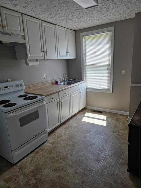 1009 11th St, Phenix City, AL 36867 - kitchen featuring white electric range oven, under cabinet range hood, white cabinetry, and light countertops