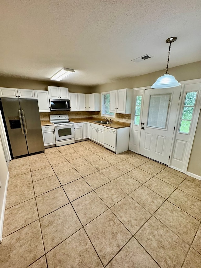 644 Parkwood Dr, Columbus, GA 31907 - kitchen featuring stainless steel appliances, a textured ceiling, white cabinetry, light tile patterned floors, and decorative light fixtures