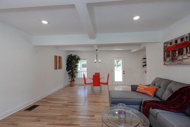 living room with beamed ceiling, a notable chandelier, and light wood-type flooring