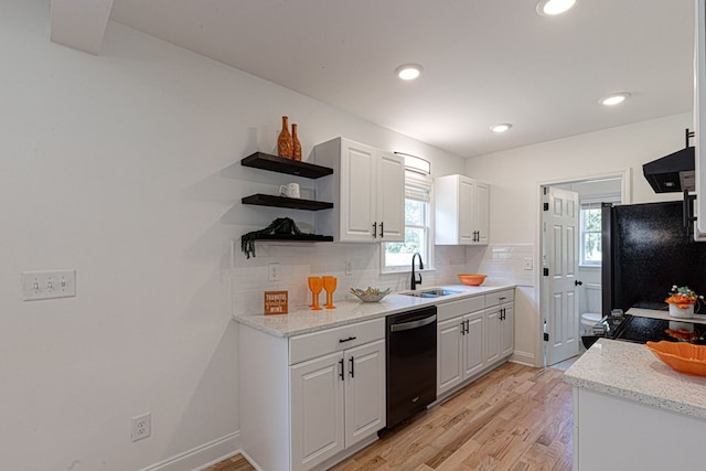 kitchen featuring sink, range hood, tasteful backsplash, black appliances, and white cabinets