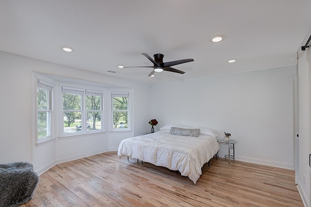 bedroom with light hardwood / wood-style floors and ceiling fan