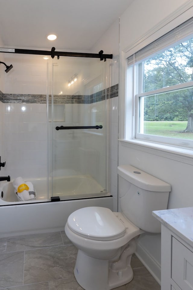 full bathroom featuring toilet, vanity, and bath / shower combo with glass door