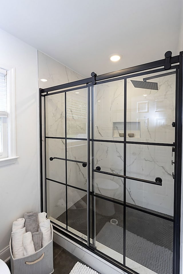 bathroom with tile patterned flooring and a shower with door