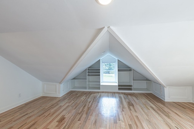 additional living space with lofted ceiling and light wood-type flooring