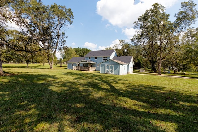 back of house with a yard and a storage shed