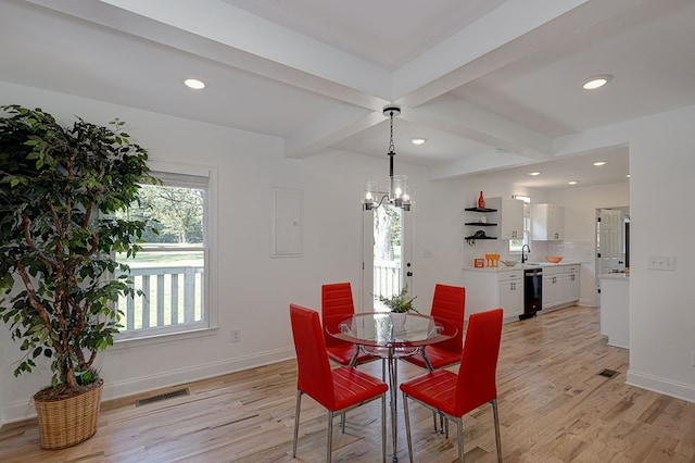 dining room featuring sink, light hardwood / wood-style floors, a chandelier, and beamed ceiling