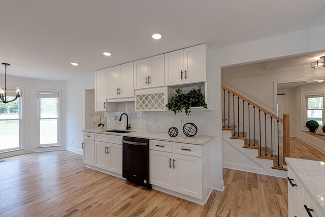 kitchen featuring white cabinetry, dishwasher, sink, and hanging light fixtures