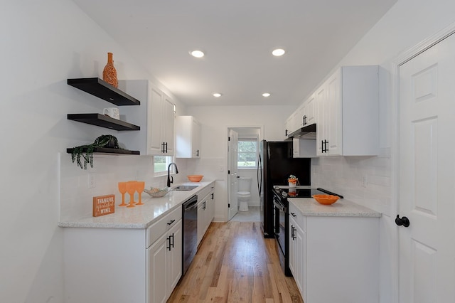 kitchen with white cabinetry, light hardwood / wood-style flooring, dishwashing machine, black range with electric cooktop, and backsplash