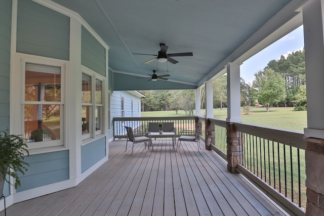 wooden terrace with ceiling fan, a porch, and a lawn