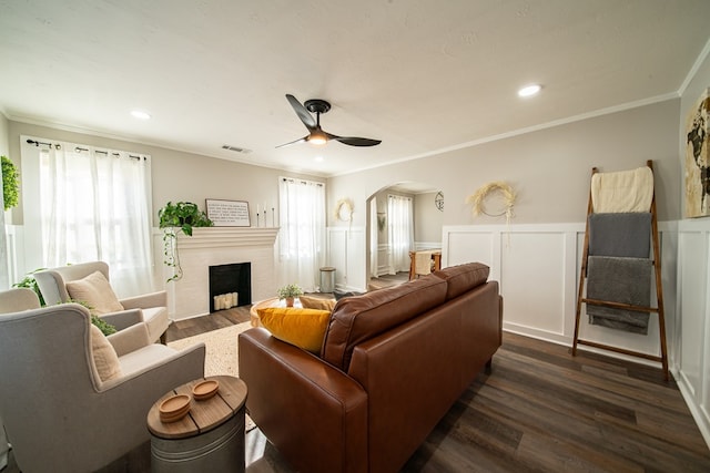 living room with dark hardwood / wood-style floors, ceiling fan, and crown molding