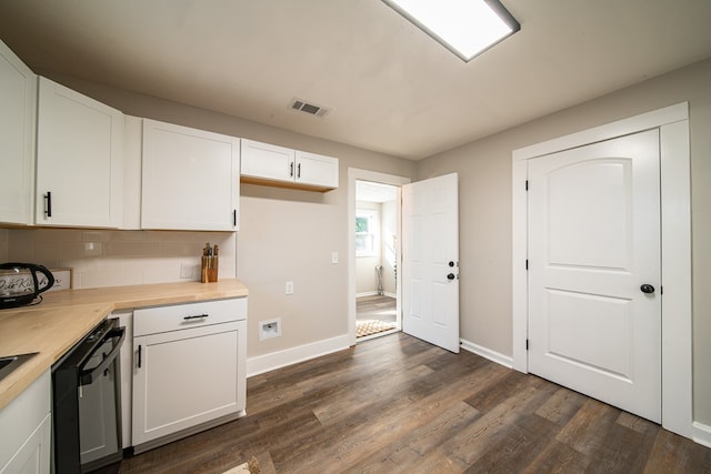 kitchen with wood counters, dark hardwood / wood-style flooring, backsplash, stainless steel dishwasher, and white cabinets