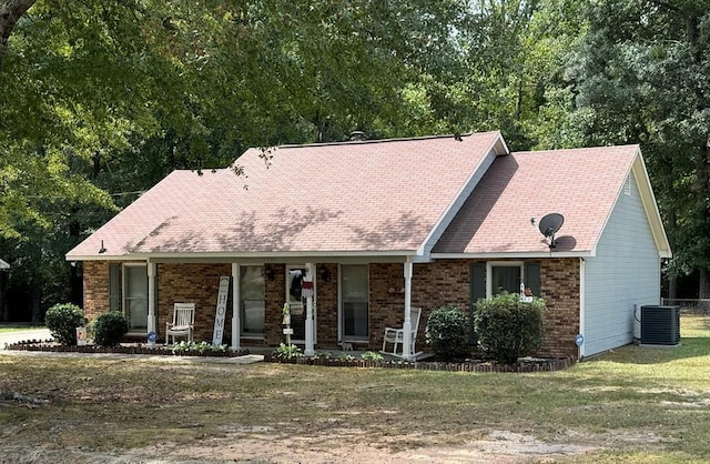 view of front of home with a front yard, a porch, and central air condition unit