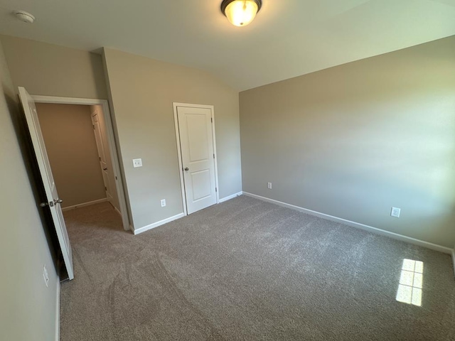 unfurnished bedroom featuring lofted ceiling, carpet floors, and a closet