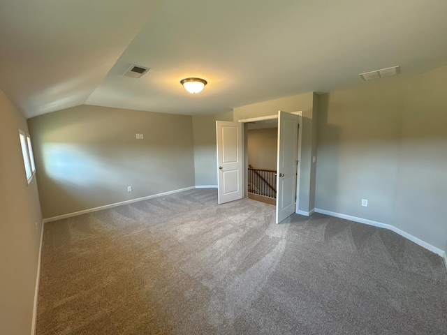 unfurnished bedroom featuring carpet floors and vaulted ceiling