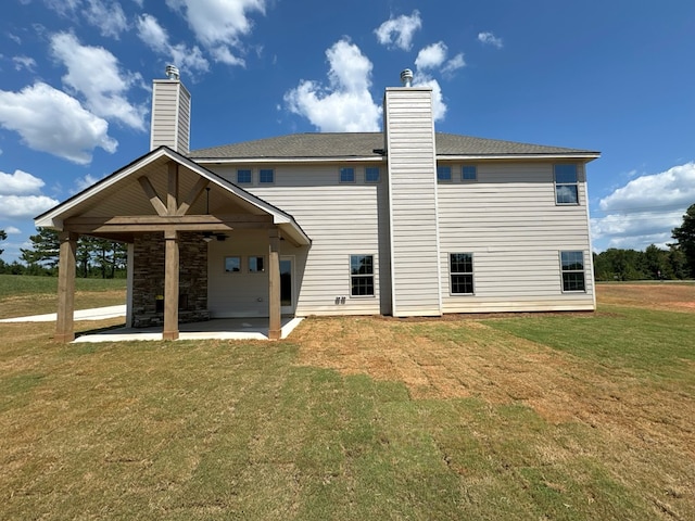 rear view of house featuring a yard and a patio area