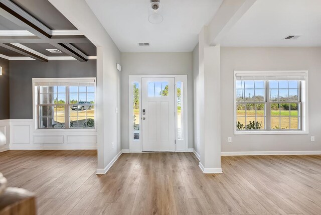 unfurnished living room with coffered ceiling, crown molding, ceiling fan, beamed ceiling, and wood-type flooring