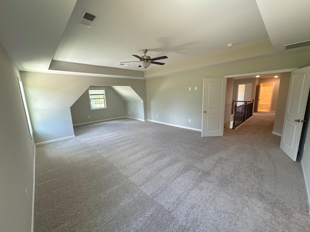 additional living space with ceiling fan and light colored carpet