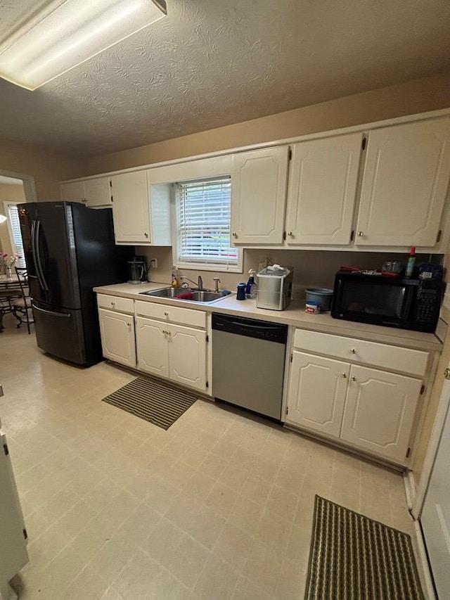 4 Kennedy St, Phenix City, AL 36869 - kitchen with black appliances, white cabinetry, light countertops, and a textured ceiling