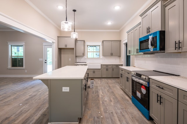 kitchen with stainless steel microwave, electric stove, gray cabinetry, ornamental molding, and wood finished floors