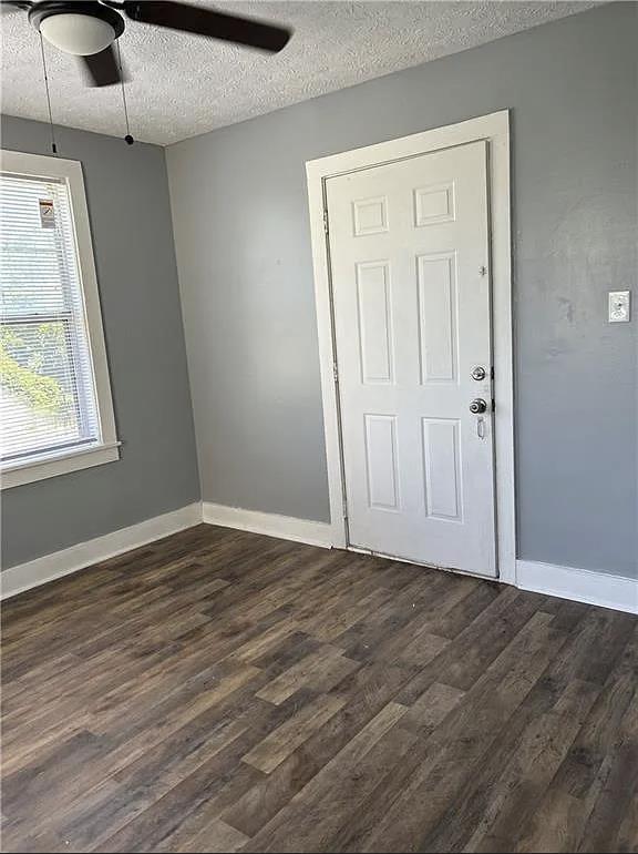 2717 Baldwin St, Columbus, GA 31906 - unfurnished room with a textured ceiling, dark wood-style floors, baseboards, and ceiling fan