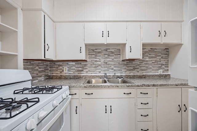 kitchen featuring sink, white range with gas stovetop, white cabinets, and tasteful backsplash