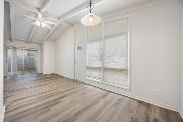 empty room featuring ceiling fan, vaulted ceiling with beams, and wood-type flooring