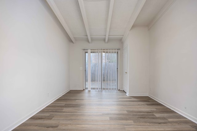 unfurnished room with beamed ceiling and wood-type flooring