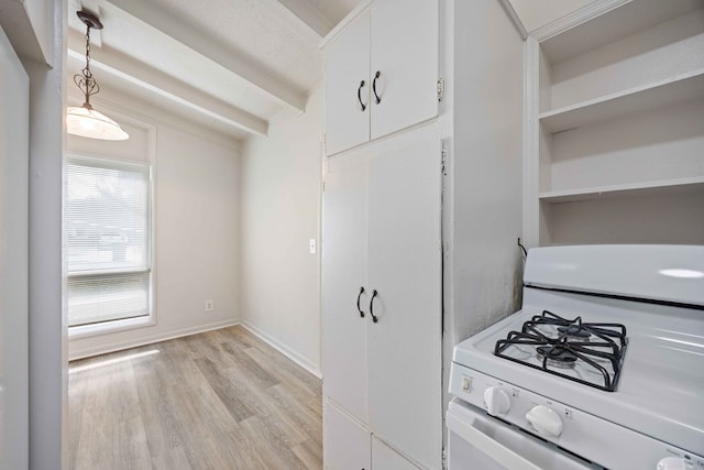 kitchen featuring light wood-type flooring, pendant lighting, white cabinetry, white gas range oven, and beam ceiling