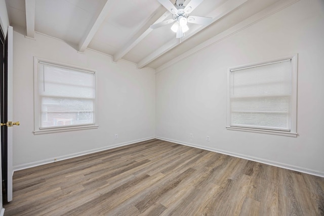 spare room with ceiling fan, lofted ceiling with beams, and wood-type flooring