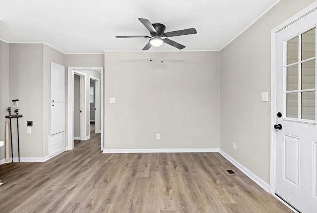 spare room featuring visible vents, wood finished floors, ceiling fan, and crown molding