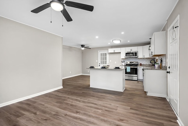 kitchen with decorative backsplash, stainless steel appliances, baseboards, recessed lighting, and a ceiling fan
