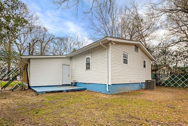 view of home's exterior with cooling unit, a lawn, crawl space, and fence