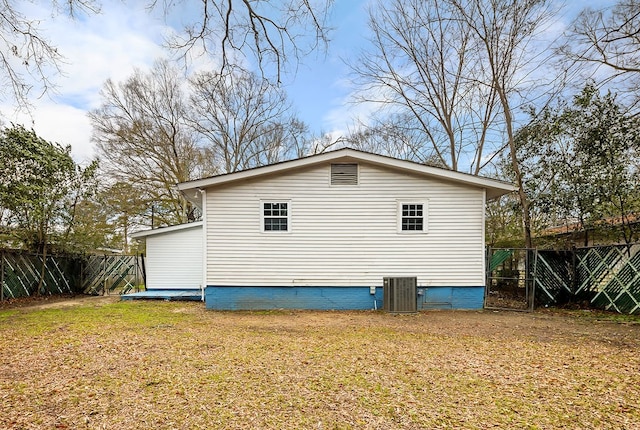 view of side of home featuring a yard, central air condition unit, crawl space, and fence
