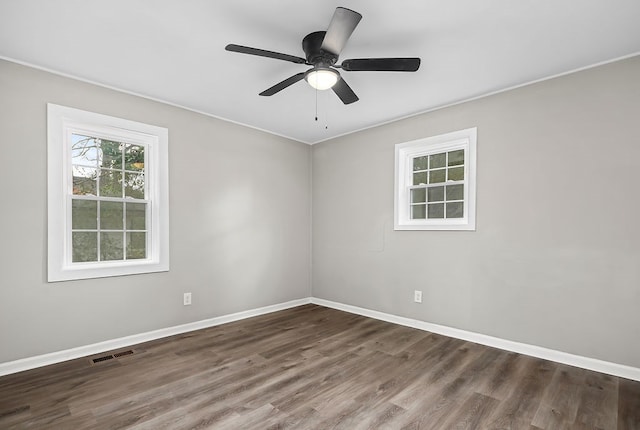 unfurnished room with visible vents, ceiling fan, baseboards, ornamental molding, and wood finished floors