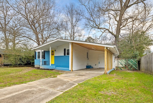 view of front facade with a front yard, a carport, concrete driveway, and fence