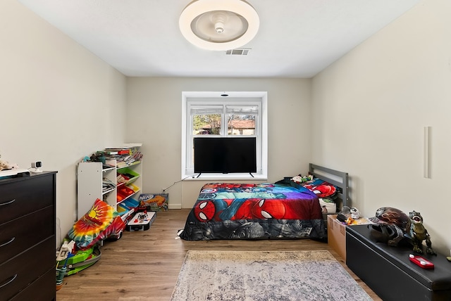 bedroom featuring light wood finished floors and visible vents