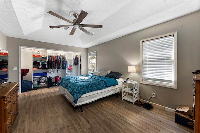 bedroom featuring a textured ceiling, ceiling fan, a closet, and wood finished floors