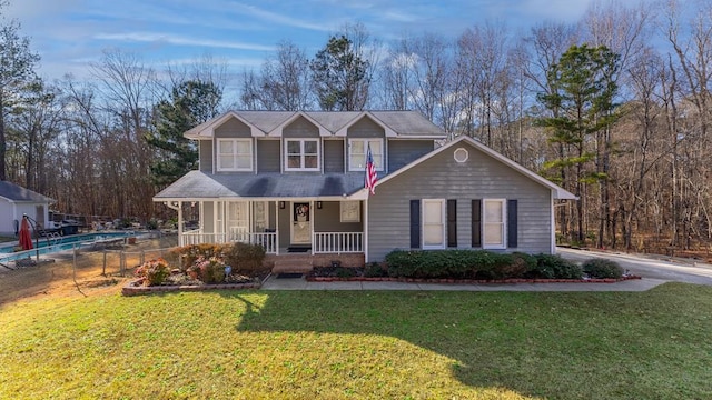 view of front of house with covered porch, fence, and a front lawn