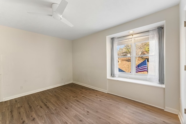 empty room with light wood-type flooring, ceiling fan, and baseboards