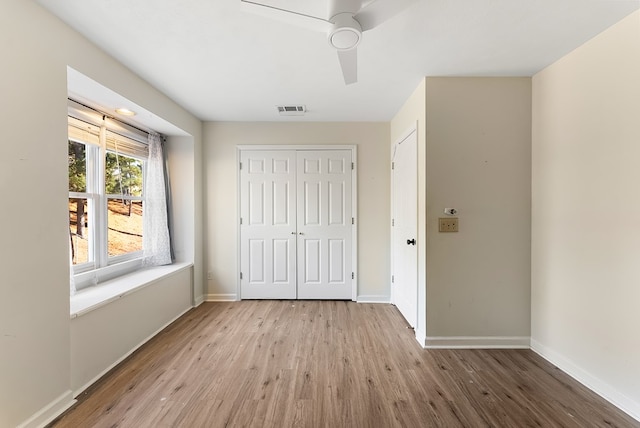 unfurnished bedroom with light wood-style floors, a closet, visible vents, and baseboards