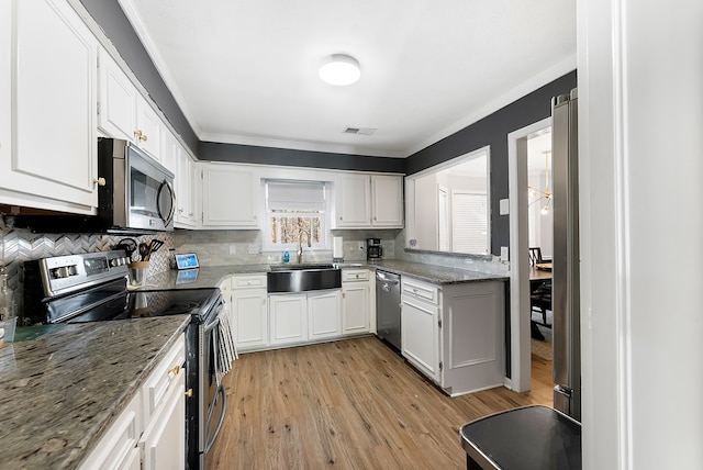 kitchen with stainless steel appliances, white cabinets, visible vents, and a sink