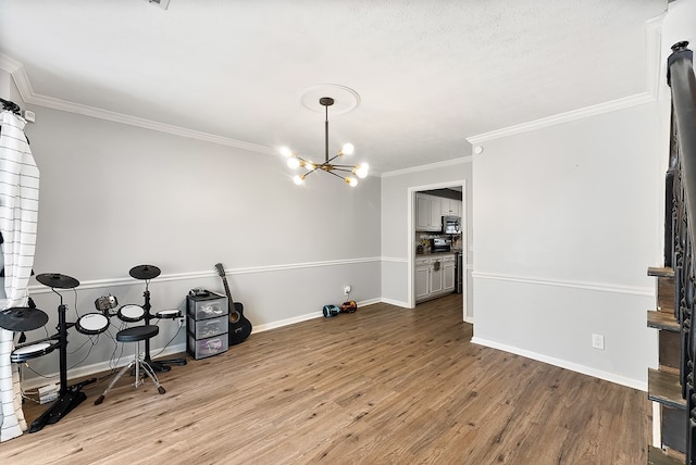 dining space featuring baseboards, ornamental molding, wood finished floors, a textured ceiling, and a chandelier