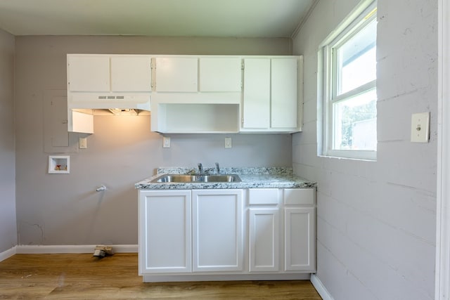 kitchen featuring light stone counters, light hardwood / wood-style floors, white cabinetry, and sink