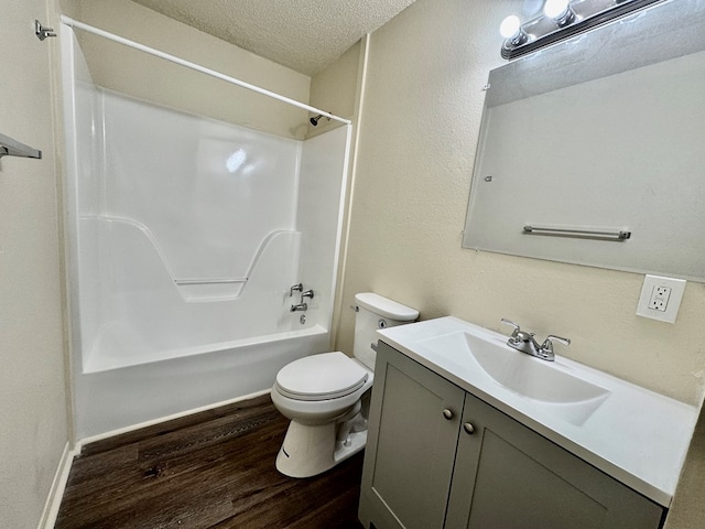 full bathroom featuring vanity, wood finished floors, toilet, a textured ceiling, and shower / bathing tub combination