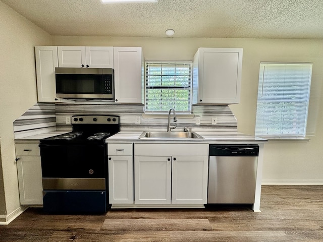 kitchen featuring a sink, decorative backsplash, stainless steel appliances, and white cabinets